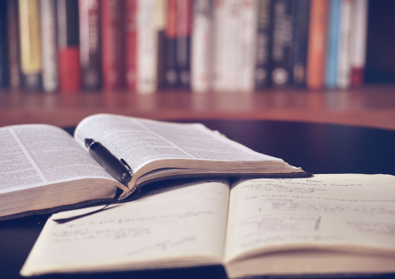 Image shows a journal and a notebook that someone is using to learn or study