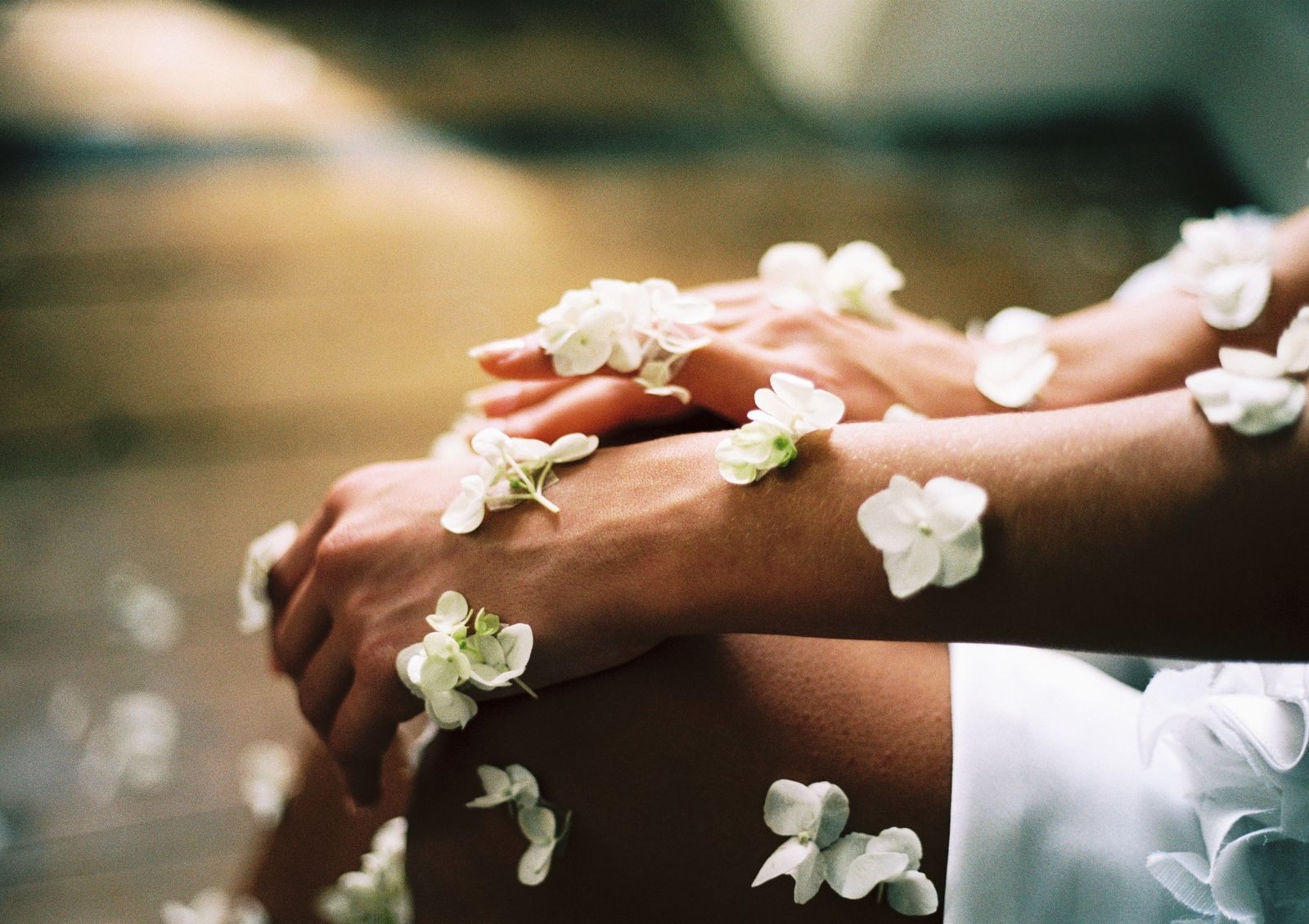 Image of a person's hands covered in beautiful flower petals designed to show self-kindness, self beauty and self-care as part of looking after our wellbeing and mental health