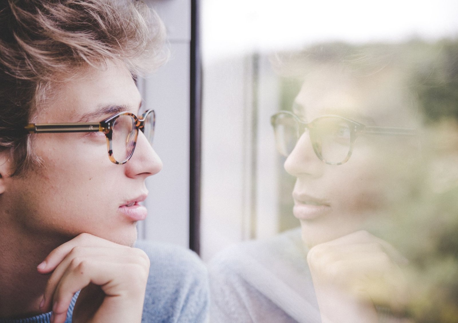 Person looking out of a window deep in thought